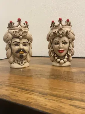 two statues of heads wearing crowns on a table at Il gallo di Eracle - Charming suites & rooms in Termini Imerese