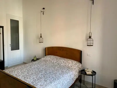 a bedroom with a bed with two lamps and two tables at Il gallo di Eracle - Charming suites & rooms in Termini Imerese