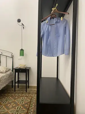 a blue shirt on a rack in a bedroom at Il gallo di Eracle - Charming suites & rooms in Termini Imerese