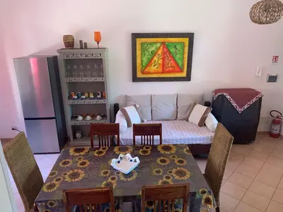 a living room with a table and a couch at MAKARI, Villetta Rocca Pirciata in Macari
