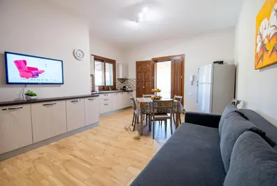 a living room with a couch and a kitchen at Deluxe Sicily Villa in Buonfornello