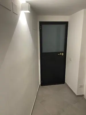 a black door in a white room with a light at Cathedral House Design in Palermo