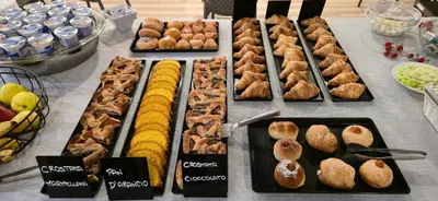 a table topped with different types of pastries and fruit at Hotel Elite Palermo Centro in Palermo