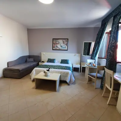 a bedroom with a bed and a couch and a table at Hotel Centrale Spa & Relax in Alcamo