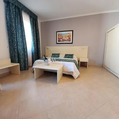 a bedroom with a bed and a table in it at Hotel Centrale Spa & Relax in Alcamo