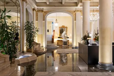 a lobby with columns and plants in a building at Grand Hotel Et Des Palmes in Palermo
