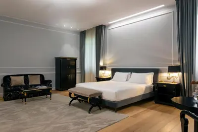 a hotel room with a bed and a chair at Grand Hotel Et Des Palmes in Palermo