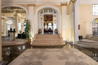 a lobby with a staircase in a building at Grand Hotel Et Des Palmes in Palermo
