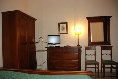 a bedroom with a tv on a dresser with a mirror at Hotel del Centro in Palermo
