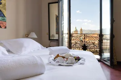a hotel room with two beds and a tray of food at Hotel Ambasciatori in Palermo