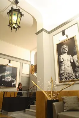 a woman standing in a hallway with a picture on the wall at Hotel Ambasciatori in Palermo