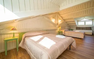 a bedroom with a large bed in a attic at Dimora Di Famiglia in Belmonte Mezzagno