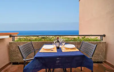 a table with a blue table cloth and a bottle of wine at Mono 2 in Lido di Mondello