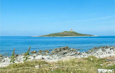 an island in the ocean with a lighthouse on it at Mono 2 in Lido di Mondello