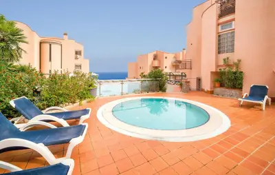 a swimming pool in a patio with two chairs at Mono 2 in Lido di Mondello