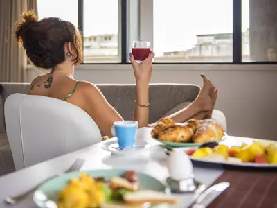 a woman sitting at a table with a glass of wine at Cristal Hotel Palermo in Palermo