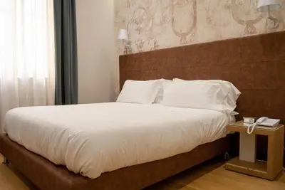 a bedroom with a large bed with a wooden headboard at Best Western Ai Cavalieri Hotel in Palermo