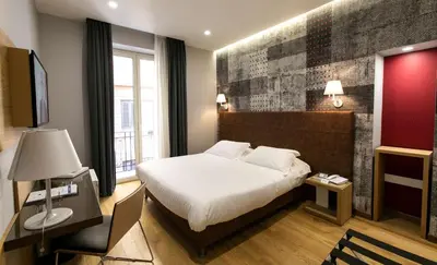 a hotel room with a bed and a desk and window at Best Western Ai Cavalieri Hotel in Palermo