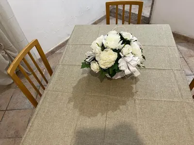 a table with a bouquet of white flowers on it at House Corso Calatafimi in Palermo