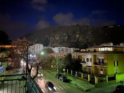 a city at night with a mountain in the background at House Corso Calatafimi in Palermo