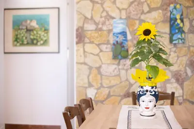a table with a vase with a sunflower in it at HolidaySicily Alcamo Marina in Alcamo Marina