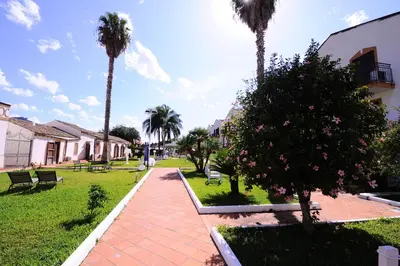 a park with palm trees and a brick sidewalk at Casena Dei Colli, Sure Hotel Collection By Best Western in Palermo