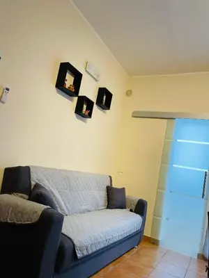a living room with a couch and some pictures on the wall at La casa di Angy in Terrasini