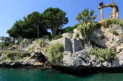 an island in the water with palm trees on it at Rocco Forte Villa Igiea in Palermo