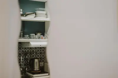 a kitchen with a shelf with dishes on it at Maravigghia Palermo Rooms in Palermo