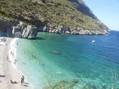 a group of people in the water at a beach at Charmrooms in Castellammare del Golfo