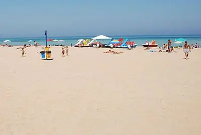 a group of people on a beach with umbrellas at Charmrooms in Castellammare del Golfo