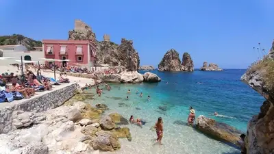 a group of people in the water at a beach at Charmrooms in Castellammare del Golfo