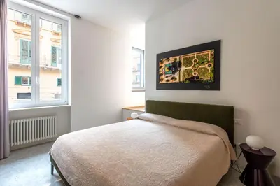 a bedroom with a bed and a painting on the wall at Sartoria Cavour - Modern Sicilian Elegance in a Former Tailor Shop in Palermo