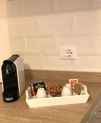 a kitchen counter with a coffee maker and tea cups at Residence D'azeglio in Palermo