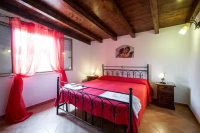 a bedroom with a red bed and a window at RESIDENCE FEDERICA in Castellammare del Golfo
