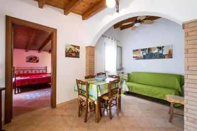 a living room with a table and a green couch at RESIDENCE FEDERICA in Castellammare del Golfo