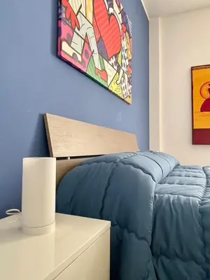a bedroom with a blue bed and a painting on the wall at Wagner House in Palermo