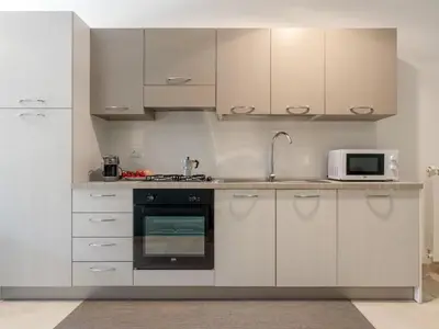 a kitchen with white cabinets and a microwave at Apartment Palermo by Interhome in Balestrate