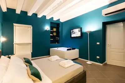 a blue bedroom with a bed and a sink at Carlo Suite Apartments con Vasca Idromassaggio in Palermo