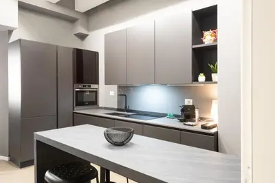 a kitchen with white cabinets and a table with a bowl on it at Carlo Suite Apartments con Vasca Idromassaggio in Palermo