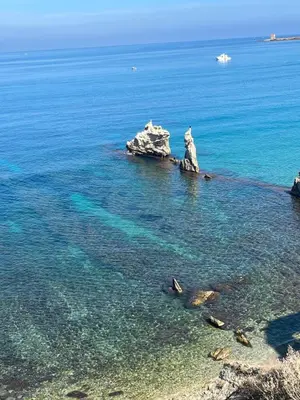 a group of rocks in the water near the shore at A-marè - CasaVacanza in Trappeto