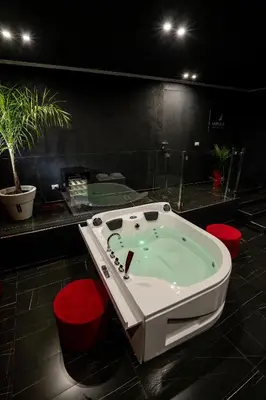 a jacuzzi tub in a room with red chairs at Marmur Suite in Palermo