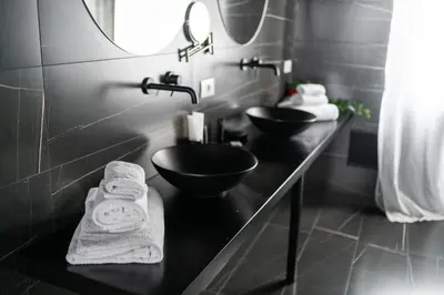 a black bathroom with a sink and a mirror at Marmur Suite in Palermo