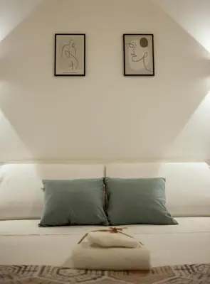 a white couch with two pictures on the wall at Agorà Home in Terrasini