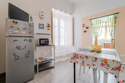a kitchen with a refrigerator and a table in a room at Casetta Holiday Meli in Palermo