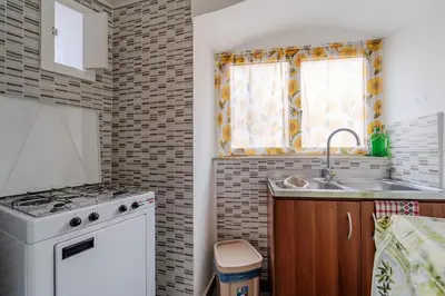 a small kitchen with a sink and a stove at Casetta Holiday Meli in Palermo