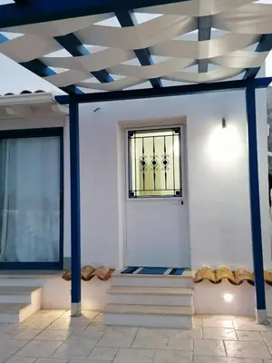 a room with blue columns and a door with a window at B&B Santorini in Cinisi