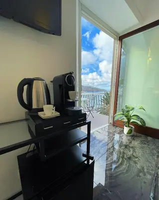 a room with a coffee maker and a large window at Suite Altamarea 