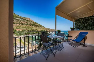 a balcony with a table and chairs and a view of the ocean at Suite Altamarea 