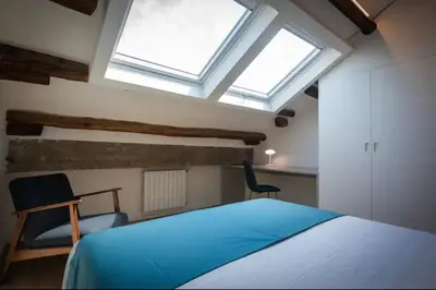 a bedroom with a bed and two chairs and a window at Kalsa Skyhome in Palermo